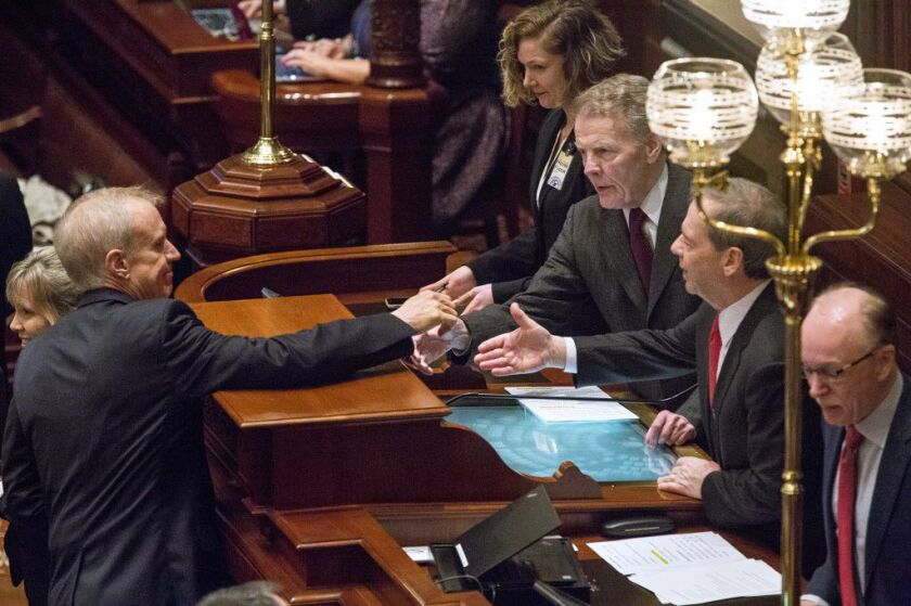 Gov. Bruce Rauner reaches out to shake hands with House Speaker Michael Madigan, D-Chicago, right middle, and Senate President John Cullerton, D-Chicago, after delivering his budget address to a joint session of the General Assembly Wednesday, Feb. 14, 20