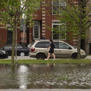 A woman walks past a flooded field at Humboldt Park, Monday, May 18, 2020. Much of the Chicago area experienced flooding after rain showers over the weekend.
