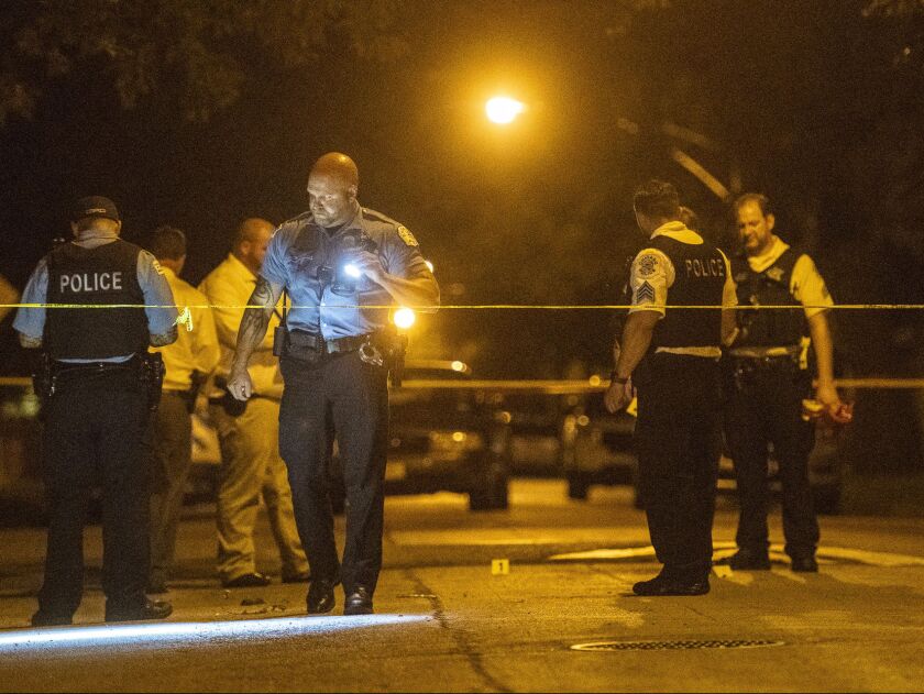 Police investigate the scene where two girls, 11 and 17, were shot Sunday night in the 11700 block of South Perry Street. | Tyler LaRiviere/Sun-Times