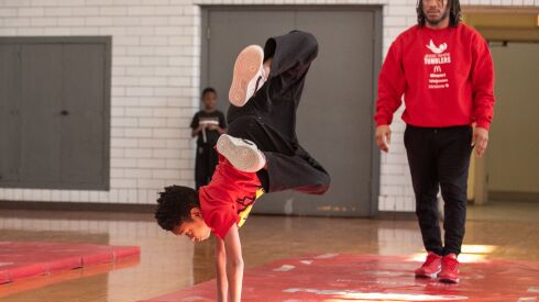 Kareem Gibbs, 9, does a cartwheel while coach Anthony Cabin watches during tryouts for the Jesse White Tumblers team at Tuley Park in the Chatham neighborhood, Saturday, Feb. 4, 2023. | Pat Nabong/Sun-Times
