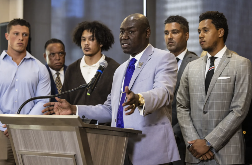 With former players (from left) Tom Carnifax, Simba Short and Lloyd Yates looking on, attorney Ben Crump speaks during a news conference Wednesday to discuss hazing in Northwestern University’s football program.Ashlee Rezin/Sun-Times