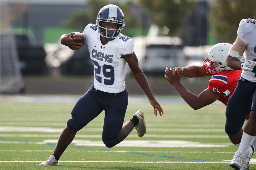 Oswego East's Jeremiah Gbean (29) carries the ball against Curie during the opening round of playoffs at Rockne.