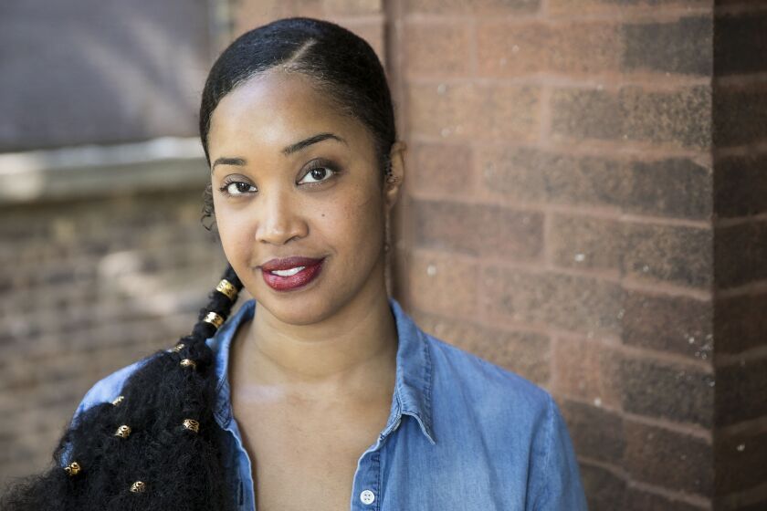 Tonika Johnson, 38, sits on the porch of her Englewood home and discusses her Folded Map art project, Wednesday afternoon, May 16, 2018. | Ashlee Rezin/Sun-Times