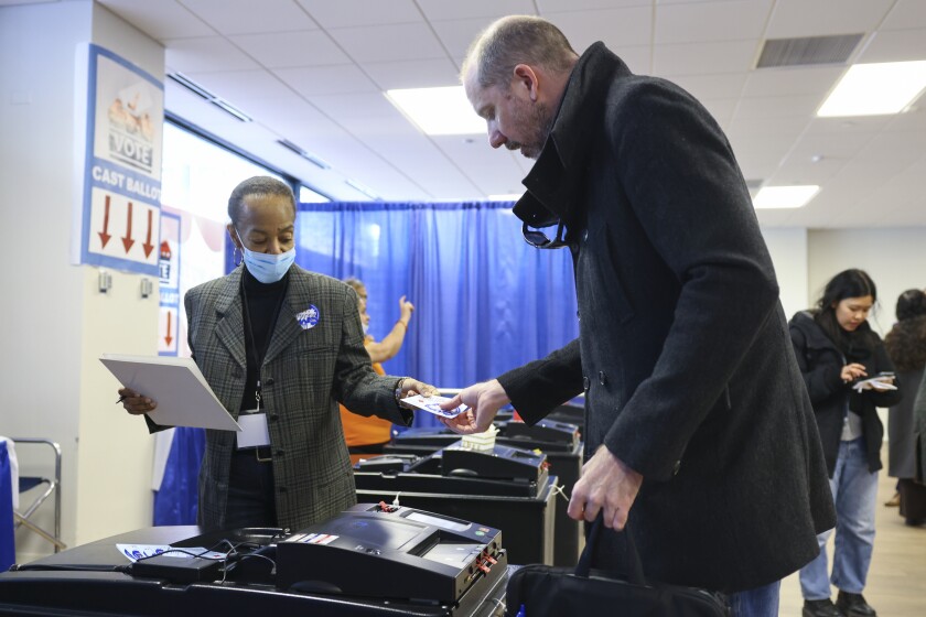 A voter submits their voter card at the Chicago Voter Supersite at 137 South State Street in the Loop, Monday, March 2, 2026.