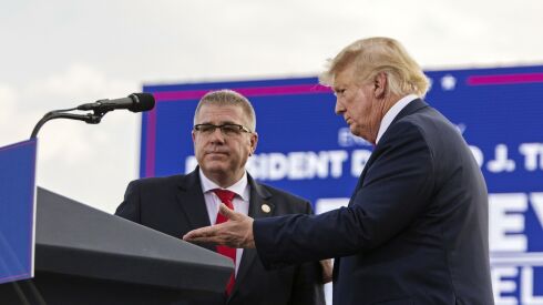 Former President Donald Trump, right, ushers gubernatorial candidate and state Sen. Darren Bailey to the podium at a rally at the Adams County Fairgrounds in Mendon, Ill., on Saturday.