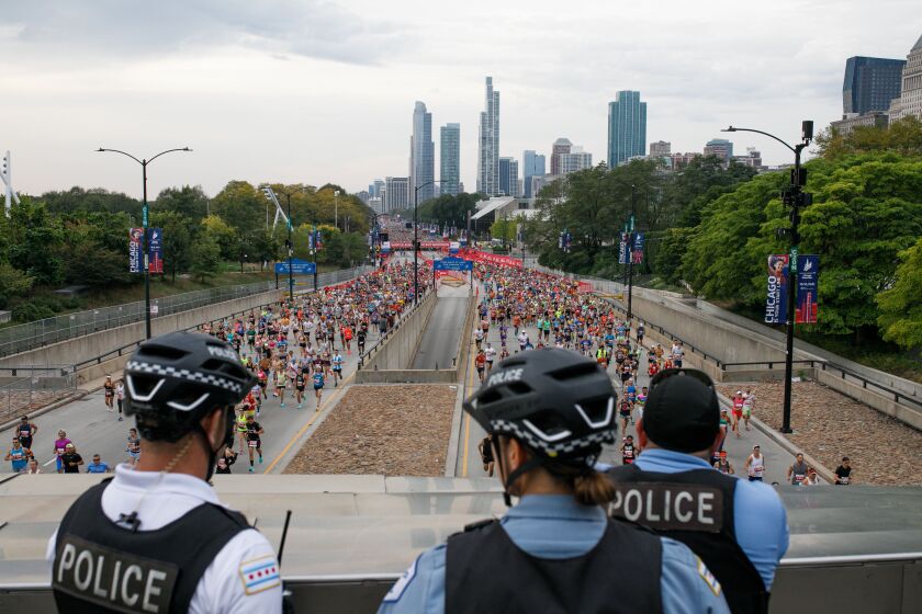 Police officers watch the start of the Chicago Marathon on Columbus Drive Sunday morning.