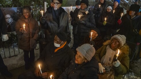 Dozens of people hold candles during a vigil on Wednesday to commemorate the 56th anniversary of the death of Fred Hampton and Mark Clark. Participants were outside the house at 2337 W. Monroe St, where the two men were assassinated.