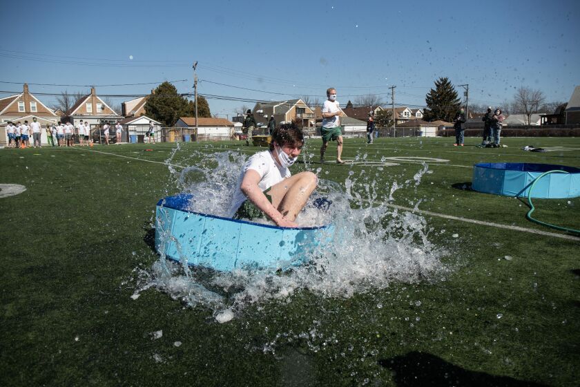 A student jumps into a wading pool filled with snow and water for St. Patrick High School’s version of the Polar Plunge.