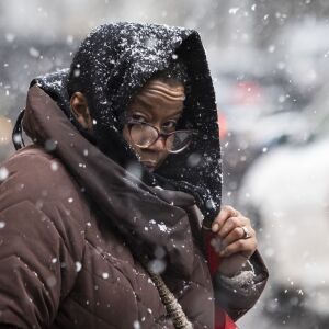 A woman walks on North Clark Street in the Loop as several inches of snow falls on the Chicago area, Thursday afternoon, Oct. 31, 2019.