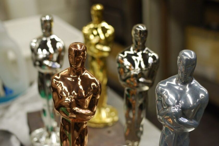 Oscar statuettes at various stages of plating – copper, nickel, silver and 24-carat gold – sit on a table at the R.S. Owens factory in Chicago on Dec. 6, 2011. | MIRA OBERMAN/AFP/Getty Images