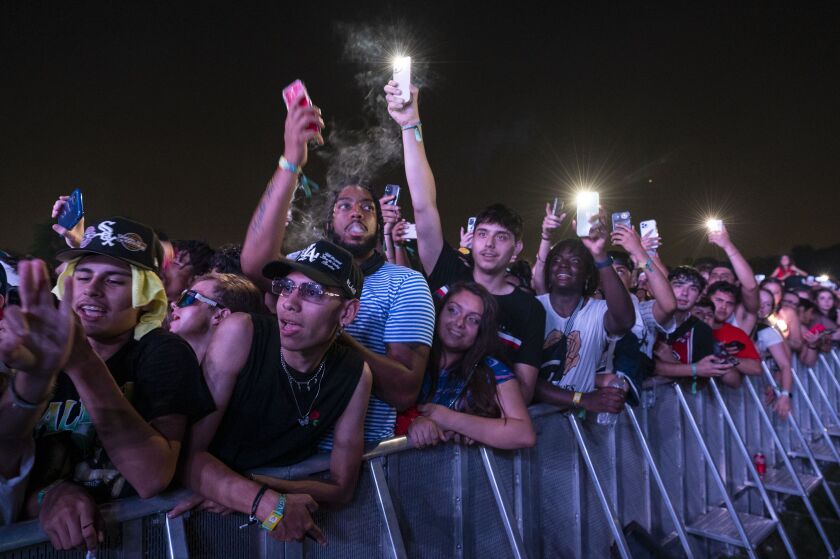 Festivalgoers hold their phones up in the air as Lil Baby performs.