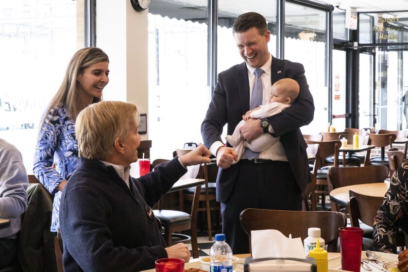 Cook County State’s Attorney candidates Bob Fioretti, left, and Bill Conway greet each other with their own fist bumps at Manny’s Cafeteria and Delicatessen.
