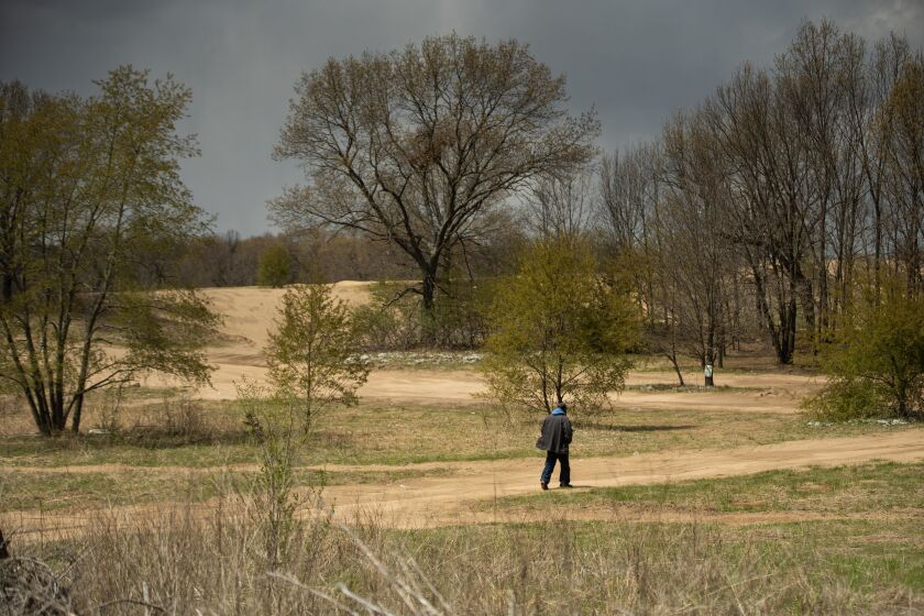 A man walks toward sand dunes in Pembroke Township, home to a rare ecosystem that’s attracted the interest of conservation groups.