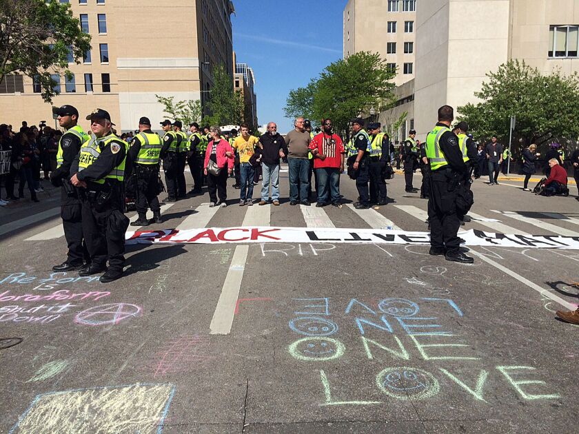 <small><strong>Demonstrators stand as police tell them to leave the street, Wednesday, May 13, 2015, in Madison, Wis., the day after a prosecutor decided not to charge Madison officer Matt Kenny for the fatal shooting of an unarmed biracial man in March.
