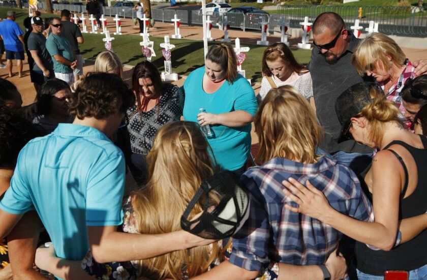 People pray at a makeshift memorial for victims of the Oct. 1 2017, mass shooting in Las Vegas, Sunday, Sept. 30, 2018, in Las Vegas. | AP Photo