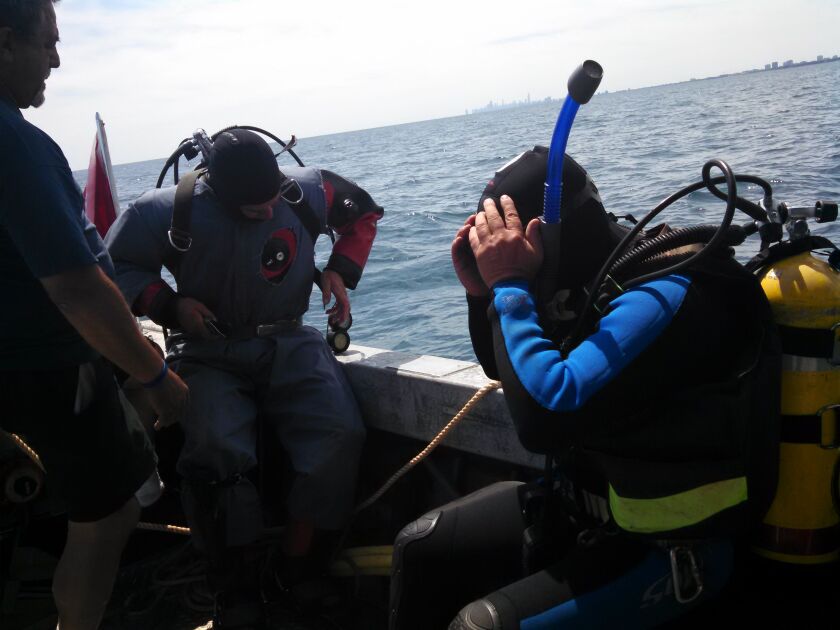 Tom Palmisano helps Jeff Strunka and Jim Pfeiffer suit up while setting the anchor for a new weather buoy off Wilmette.<br>Credit: Dale Bowman