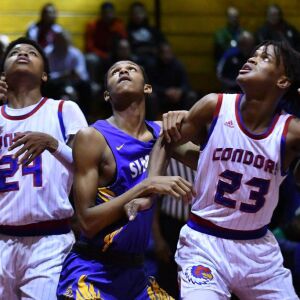 Curie’s Justin Harmon (24) and Ramean Hinton (23) box in Simeon’s Andre Casey Jr. (23). Worsom Robinson/For the Sun-Times.