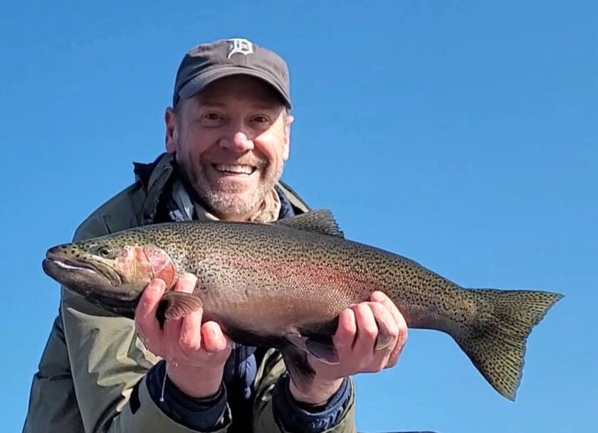 Laurance Reed with a steelhead on the lakefront, caught on what was rare this year, a high-sky day. Provided photo