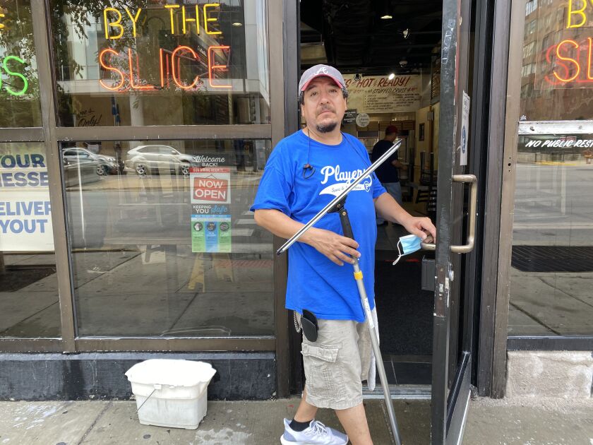 Rafael Gutiérrez cleans the windows at Art of Pizza, 727 S. State St.