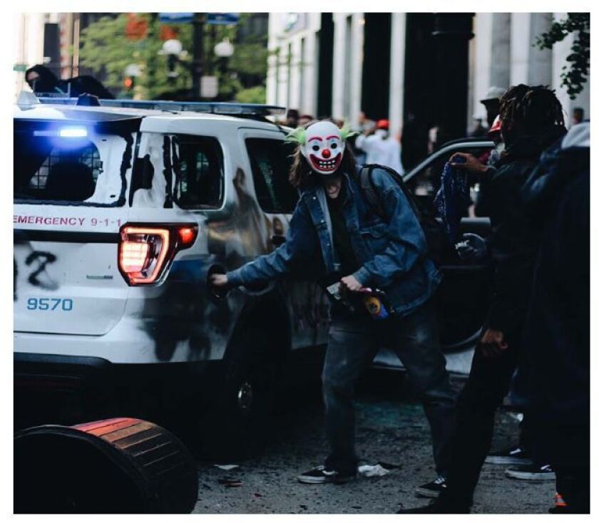 A man alleged to be Timothy O’Donnell reaches toward the gas tank of a Chicago police vehicle in Chicago.