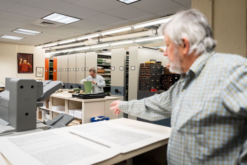 Chicago Symphony Orchestra’s librarian Mark Swanson (front) views an oversized score in the Symphony Center library.