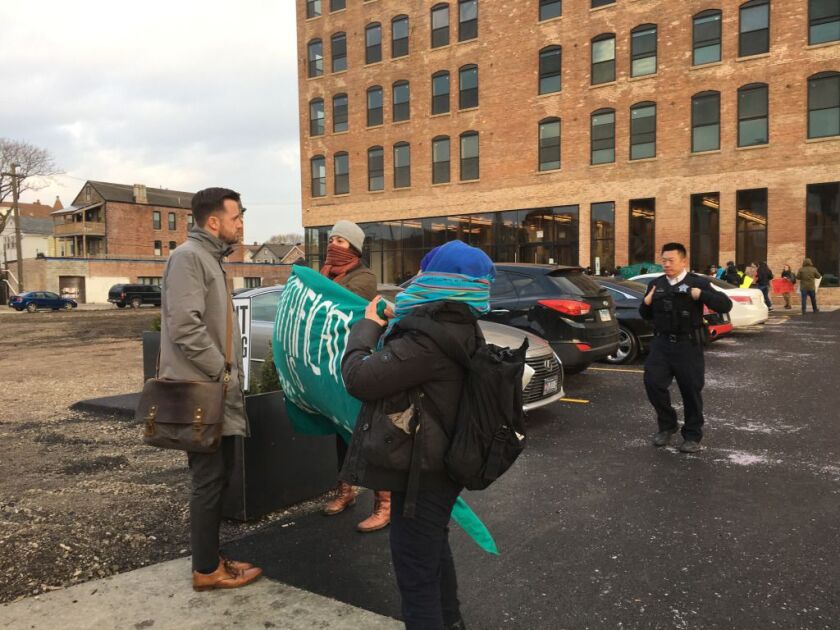 Protesters confront an attendee outside a networking event for developers and real estate brokers in Pilsen Wednesday. | Chicago Sun-Times/Carlos Ballesteros