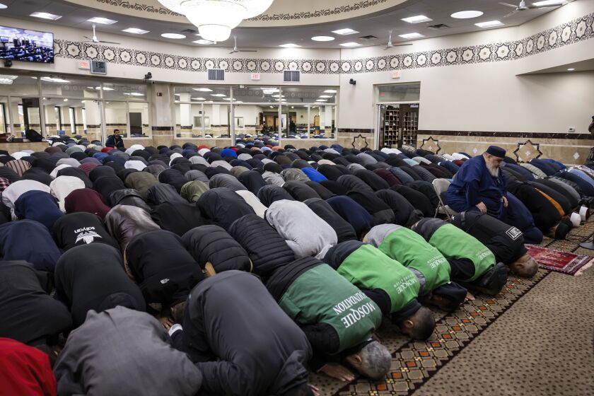 Mourners pray with their foreheads to the floor at a mosque during the funeral for 6-year-old Wadea Al-Fayoume.
