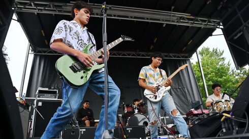 Members of the band Large Mouth strike a synchronized pose on stage during their performance at the Community Talent Showcase in Douglass Park in North Lawndale