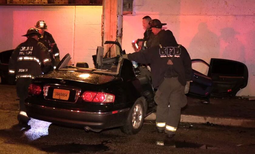 Firefighters work to free a woman from a car that crashed under a South Side viaduct Thursday night. | Network Video Productions
