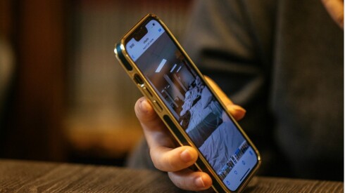 Aziz displays a photo on his phone that shows the room where he slept while staying at a refugee camp in Wisconsin.