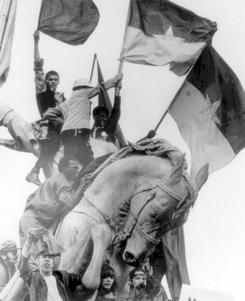 Protesters swarm a statue in Grant Park of Civil War Gen. John Logan on Aug. 26, 1968. What started as a peaceful event later erupted into riots. | AP