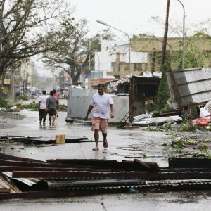 A resident walks beside toppled structures as Typhoon Mangkhut barreled across Tuguegarao city in Cagayan province, northeastern Philippines early Saturday, Sept. 15, 2018. The typhoon slammed into the Philippines northeastern coast early Saturday, itR