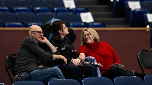 Margaret Storey (right) smiles next to Jonathan Heller (left) and her daughter Josie Heller (22, center, in wheelchair) while attending the Evanston Symphony Orchestra's barrier-free holiday concert at Evanston Township High School on Sunday, Dec. 14, 2025.