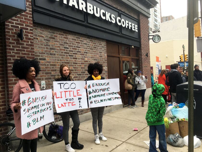 Demonstrators protest in April outside the Starbucks cafe in Philadelphia where two black men were arrested for waiting inside without ordering anything. On Tuesday, the company plans to close more than 8,000 stores nationwide to conduct anti-bias trainin
