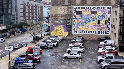 Two murals recognizing the women's suffrage movement appear on side of a building, one showing a yellow flower and one featuring the "... I'm speaking" phrase that Kamala Harris said during a vice presidential debate.