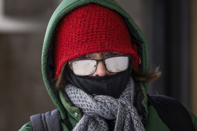 A pedestrian walks through the Loop as temperatures across Chicago hover around 0 degrees, Tuesday, Jan. 16.