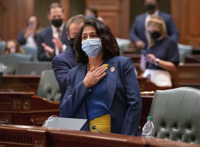State Rep. Lisa Hernandez, D-Cicero, holds her hand over her heart as she is thanked by state Rep. Jehan Gordon-Booth, D-Peoria, after passage of the Illinois legislative maps proposal on the floor of the Illinois House Tuesday night.