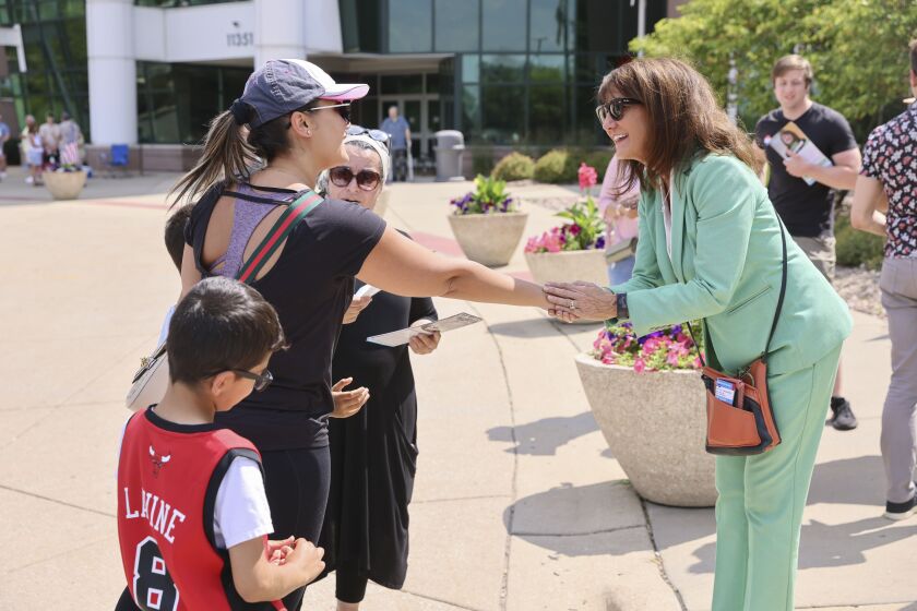 Democratic U.S. Rep. Marie Newman, right, greets people at a polling place in Orland Park on Tuesday.