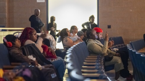 Simeon parents watch their chidlren perform in a play.