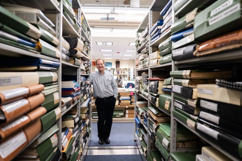 CSO principal librarian Peter Conover stands among some of the more than 5,000 sets of scores and musicians’ parts — some dating back a half-century or more — with even older ones from the earliest days of the orchestra now residing in the symphony’s historical archives. 