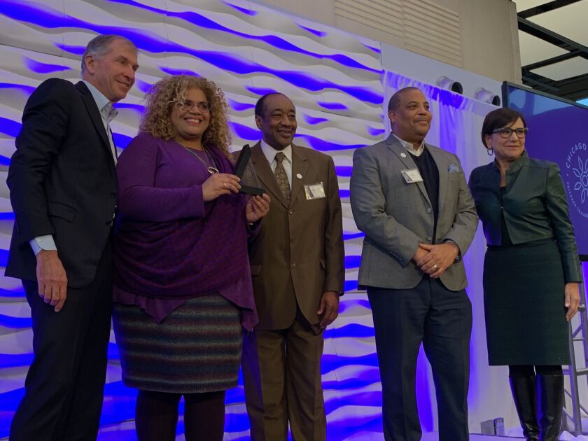 The Auburn-Gresham community development team accepts its Chicago Prize Challenge finalist award from Bryan Traubert and Penny Pritzker of the Pritzker Traubert Foundation on Wednesday.