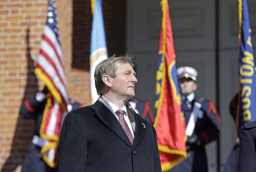 Irish Taoiseach Enda Kenny listens to the Irish national anthem after his arrival at the Massachusetts Statehouse on Monday in Boston. | Elise Amendola/Associated Press