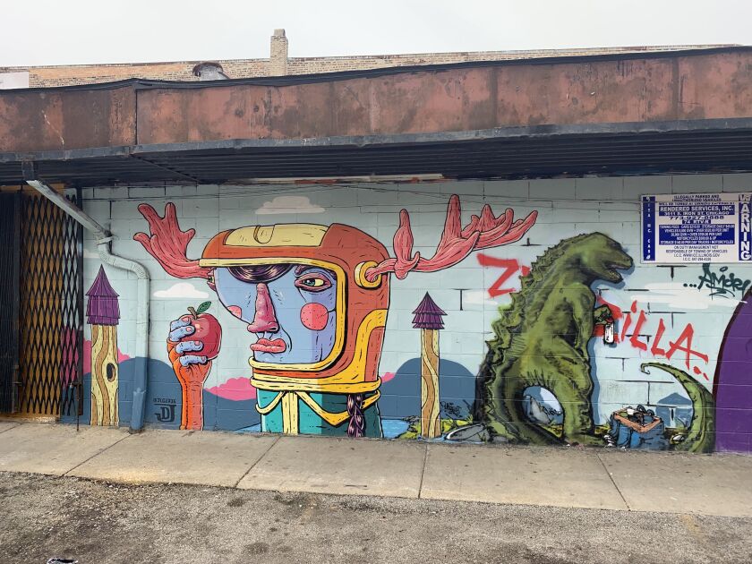 Part of the Little Village mural on a Mexican market, with the image of the character with antlers by the artist Joey D., and the image to the right by the artist who goes by Zwonzilla.