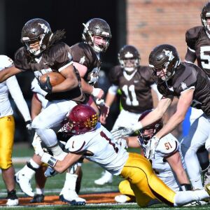 Joliet Catholic’s Keenan Hailey (27) step over Montini’s Scott West (1). Worsom Robinson/For the Sun-Times.