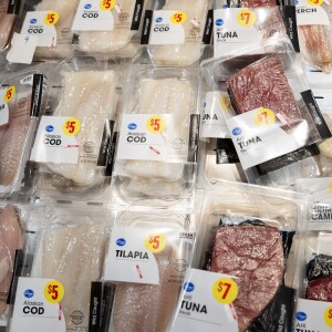 A display of packaged fish at a grocery store.