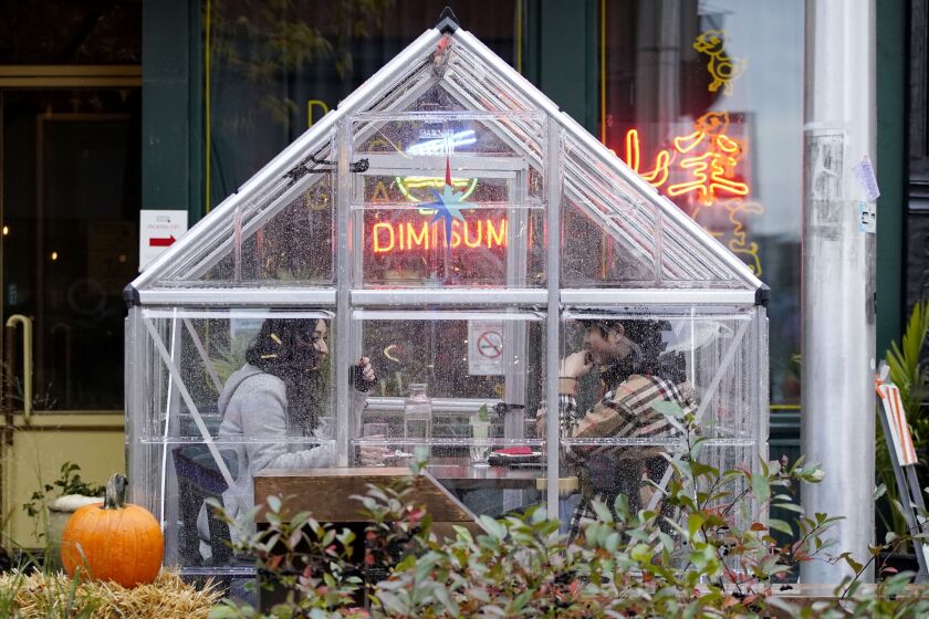 People eat in a greenhouse structure at Duck Duck Goat restaurant on Fulton Market in Chicago on Sunday.