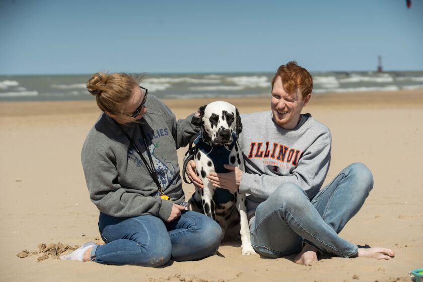 Zach Eckhart (left) and his girlfriend Jessica Guballa pet their dog, Charlie, on Saturday at Montrose Beach in the Uptown neighborhood.