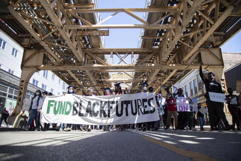 Protestors hold a banner that reads “Fund Black Futures” on East 63rd Street in Woodlawn during a June 14, 2020, demonstration against police officers in schools.