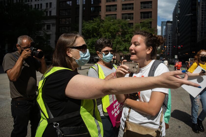 Jessica Droger, a marshal with Indivisible Chicago, asks pro-life activist Emily Iverson to step aside during the “Bans Off My Body” rally Friday afternoon at Federal Plaza in the Loop.