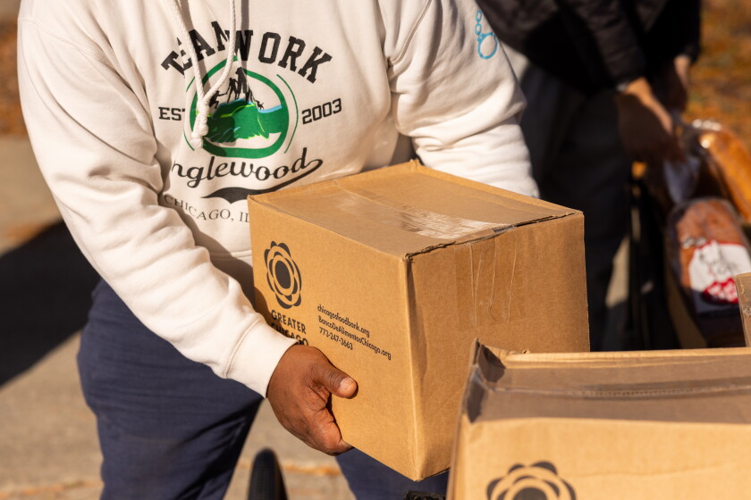 A steward grabs a box of nonperishables during an emergency food giveaway organized by Grow Greater Englewood and the Englewood Food Sovereignty Network in partnership with the Greater Chicago Food Depository on the South Side, Saturday, Nov. 15, 2025. | Candace Dane Chambers/Sun-Times.